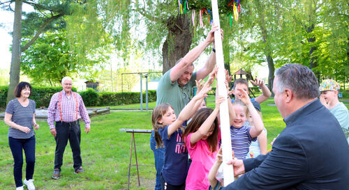 Lachender Nachwuchs stellt den Maibaum in Windeseile