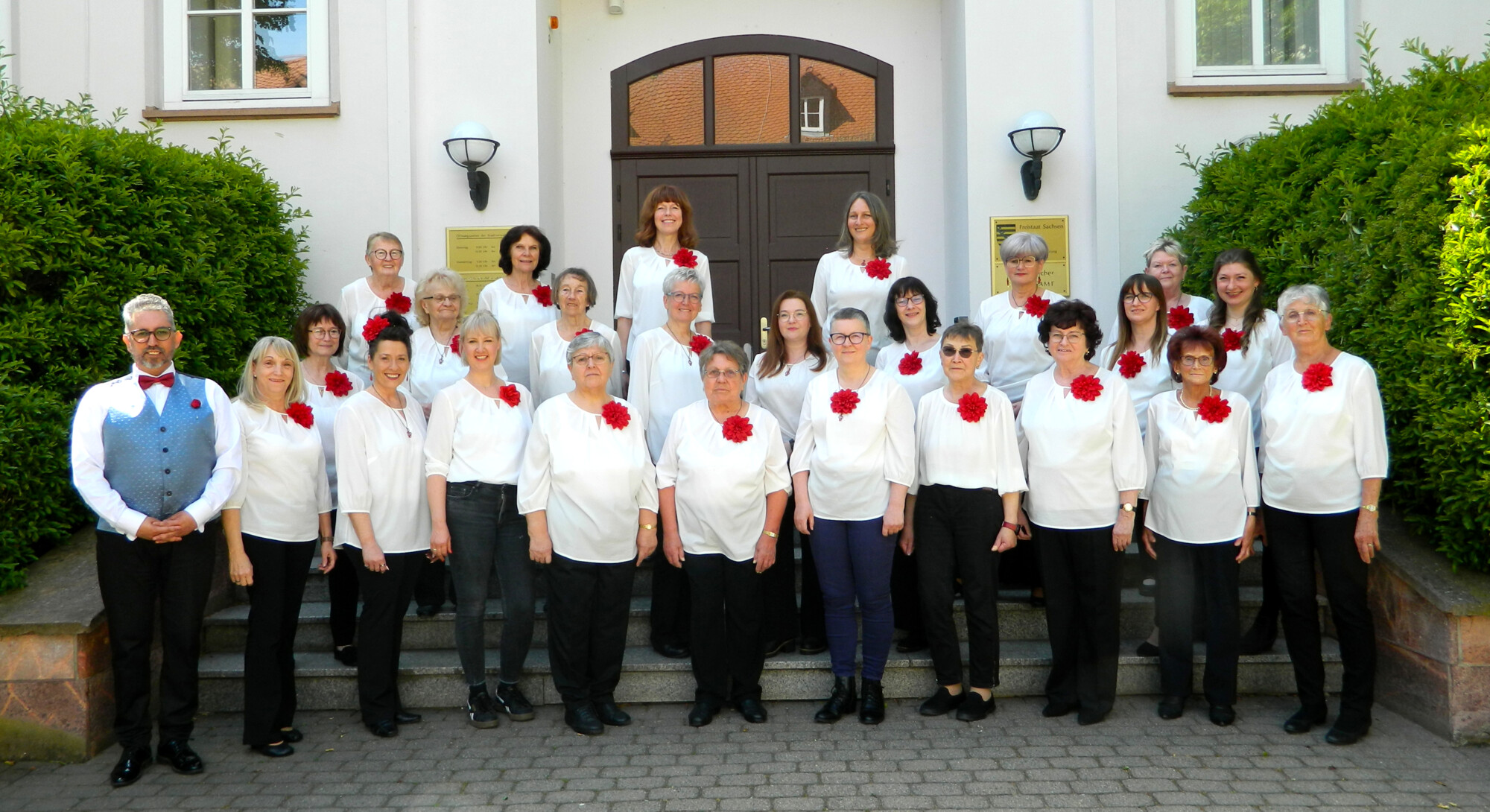Der Frauenchor Kitzscher präsentiert sich gemeinsam mit seinem musikalischen Leiter auf der Eingangstreppe zum Rathaus vor dem Frühlingskonzert