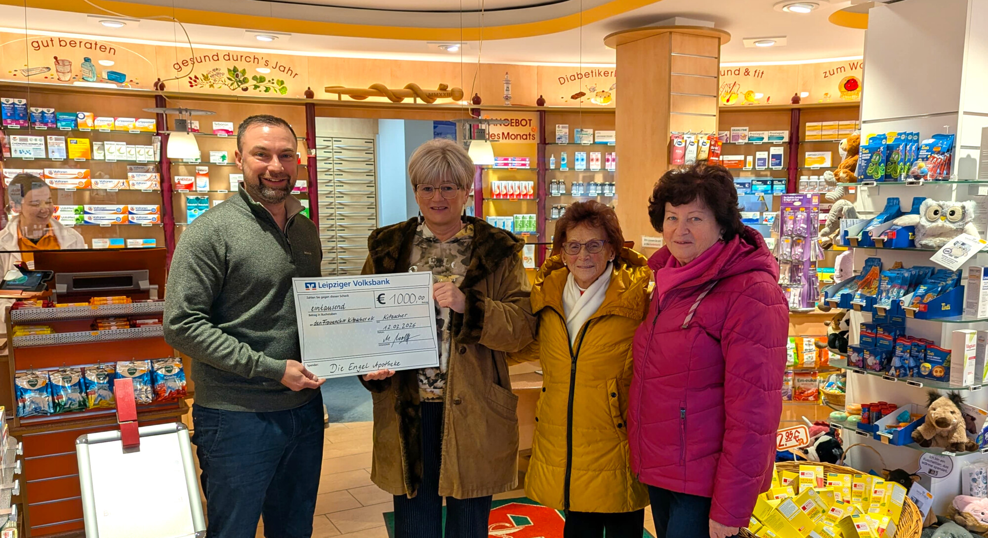 Scheck&uuml;bergabe im Verkaufsraum, Die Engel Apotheke-Gesch&auml;ftsf&uuml;hrer Michael Wolff &uuml;bergibt den Scheck an Katharina Hiller (Vereinsvorsitzende Frauenchor), Ursula Meusel ehem. und langj&auml;hrige Vereinsvorsitzende Frauenchor) und Sigrid Illgen (Mitglied Frauenchor)