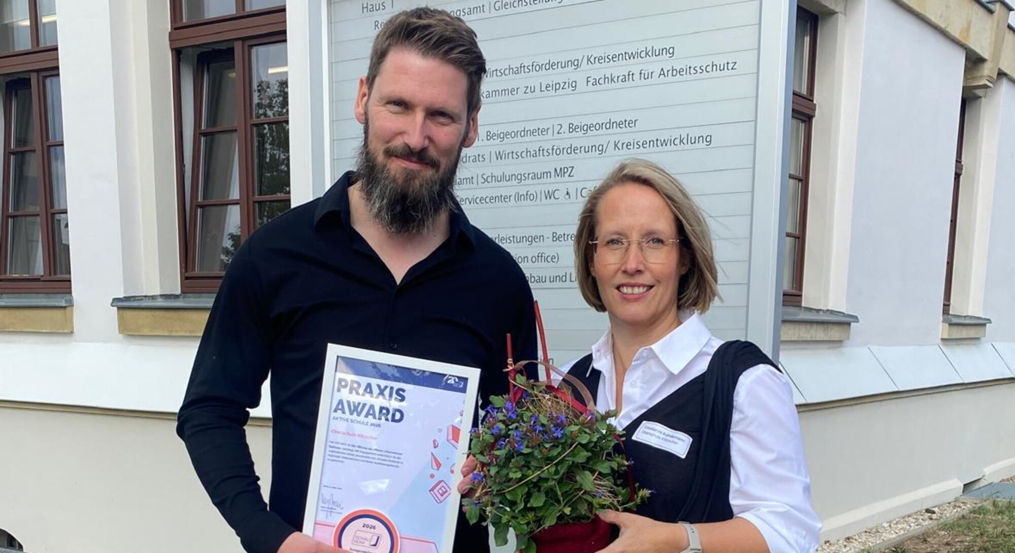 Frau Kahdemann (re.) und Herr R&ouml;wer erhalten f&uuml;r das Engagement des Teams der Oberschule stellvertretend den Praxis Award &bdquo;Aktive Schule 2026&ldquo; im Landratsamt Landkreis Leipzig in Borna &uuml;berreicht